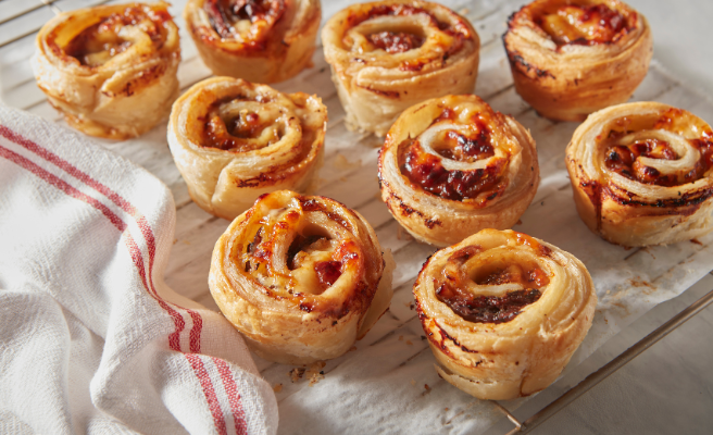 Puff pastry dough swirled with French onion soup flavor displayed on a countertop.