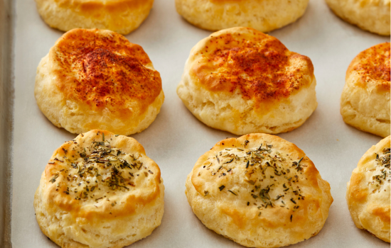 A variety of topped biscuits on a metal serving tray